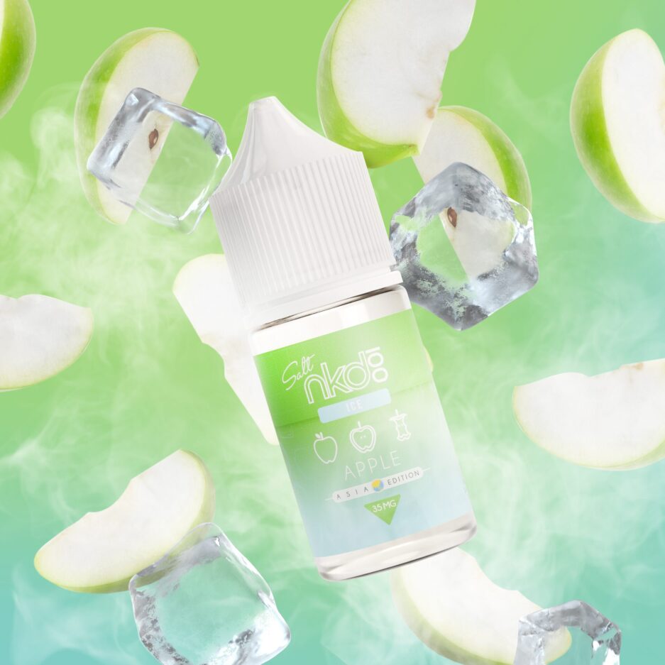 Asia Apple is floating with an array of slices of green apples behind it, ice cubes float near the bottle, smoke dissipates into the air coming from below.