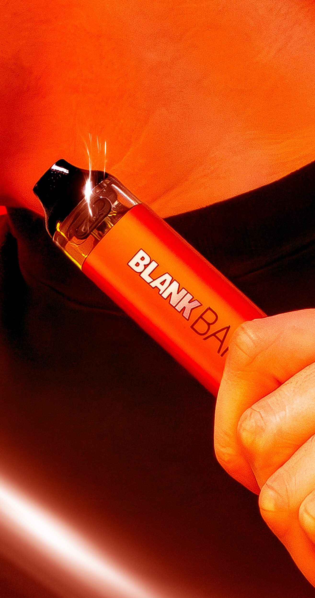 Where everything is illuminated by a neon orange light, a tight shot of a man holding a Blank Bar + Hybrid Disposable up to his chest, with a light glare o the bottom left of the screen and a light refracting off the pod of the disposable.