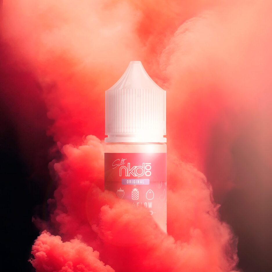 A giant cloud of red smoke rises in the air as it begins to consume a bottle of Nkd Salt Asia Lava Flow