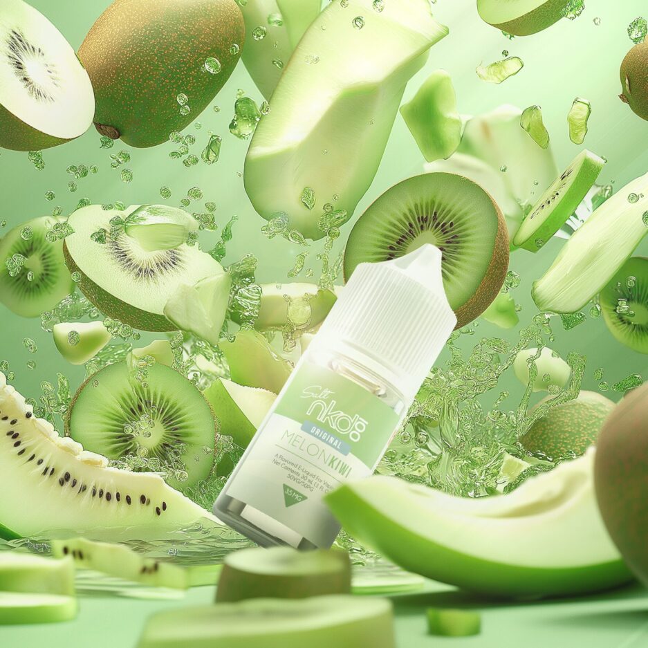 A product photo of Naked100 internationals Melon Kiwi at the center of an image of an assortment of kiwis, melons, and green apple slices flying in the air with green colored liquid splashing in the air as well all in the background of the bottle. The surrounding area is full of green colored tones and said fruit lying in the foreground in front of the bottle, All to give the feeling of immense flavor that comes form the product.