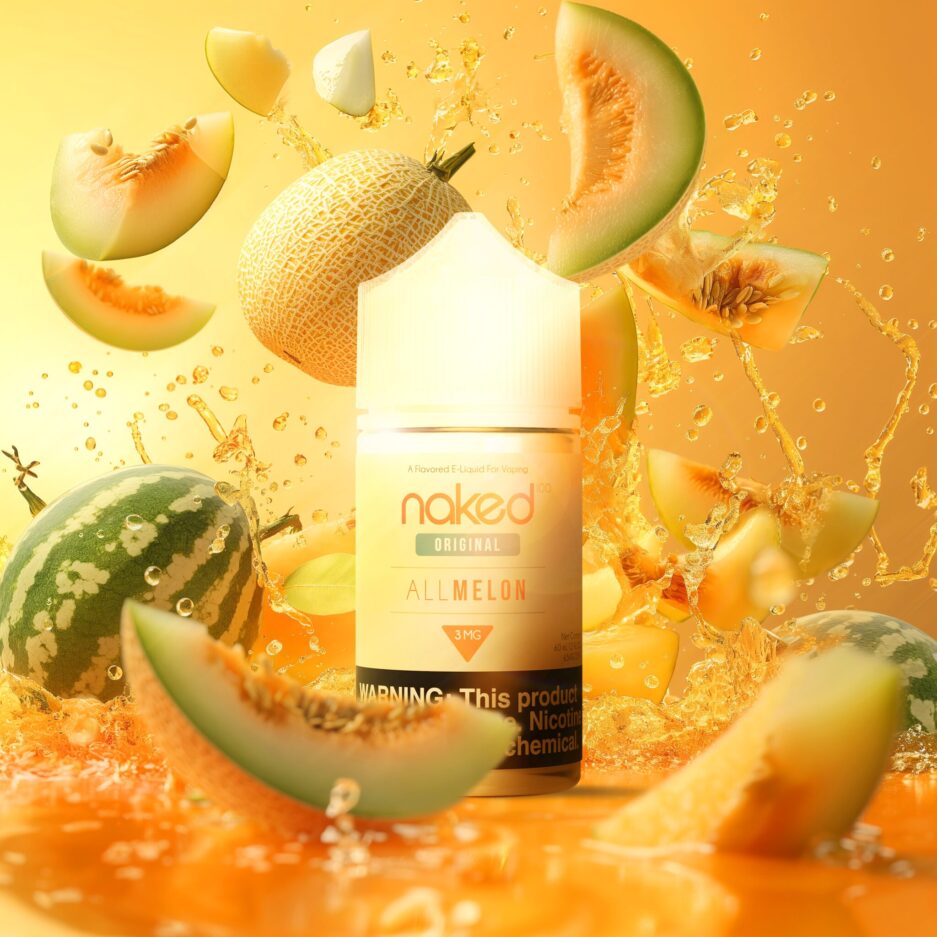 A product shot of Naked 100's International lines "All Melon" 60mL bottle standing in the middle of the image. An orange floor and wall to match the product color. Watermelon, Cantaloupe, and Honeydew pieces are spread throughout the image with juice from the fruit splashing everywhere as well to give the sense of pure and exaggerative flavor that the product provides.