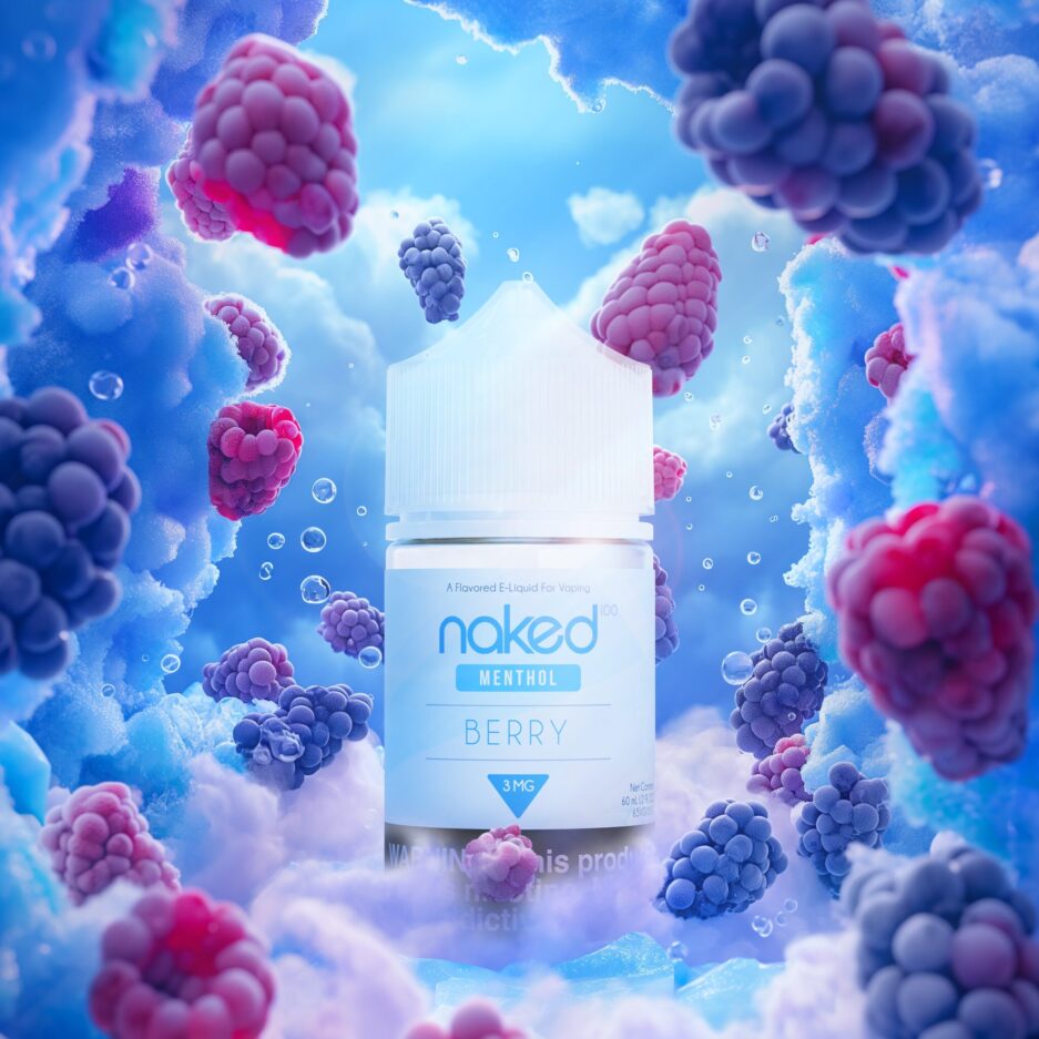 A product shot set in a icy landscape of Naked 100's International Menthol lines "Berry" 60mL bottle standing at the center of the image. The image provides a cold and blue color tone to suggest the "coldness" menthol provides, with Raspberries and blackberries spread throughout the foreground and background of the image, all pointing the viewers eye towards the product. Smoke peers through the bottom of the image, with the product at the center peering out and on top of it.