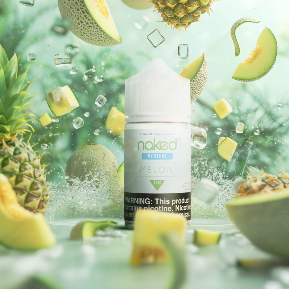 A product shot with Naked 100's Melon 60mL bottle standing in the middle of the image, The atmosphere is a cool light green and blue color tone mix to appear in the same likeness as the product, with Pineapples and Melons spread throughout each part of the image, all leading the eye towards the product, ice cubes and water are splashing around the image as well to give the "cool" feeling.